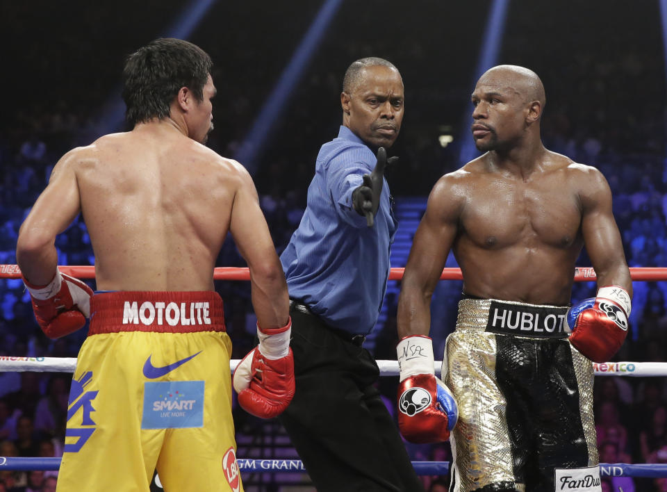 Referee Kenny Bayless separates Manny Pacquiao, from the Philippines, left, and Floyd Mayweather Jr., during their welterweight title fight on Saturday, May 2, 2015 in Las Vegas. (AP Photo/Isaac Brekken)