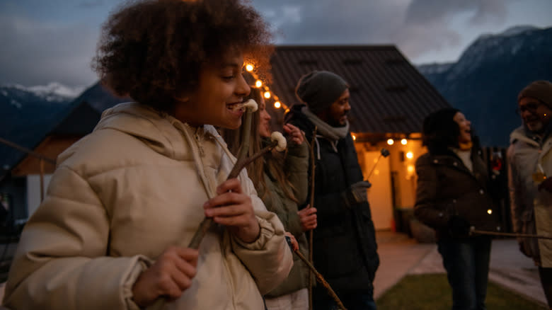 person eating marshmallows on stick