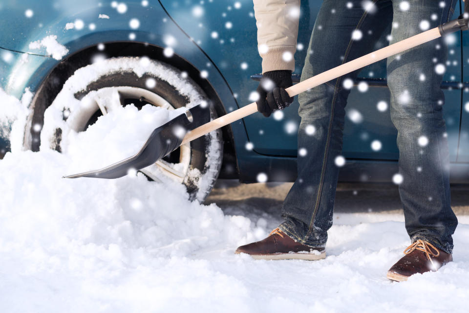 Man uses incorrect posture when shoveling driveway, bending from back, not from knees