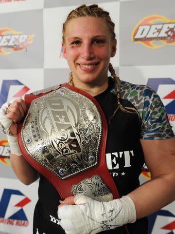 <p>Etsuo Hara/Getty</p> Amanda Lucas poses with the belt in her post match media conference after the DEEP57 fight against Yumiko Hotta on February 18, 2012 in Tokyo, Japan.