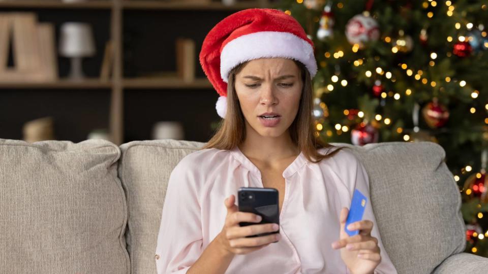 Une femme fait ses achat de Noël sur son téléphone