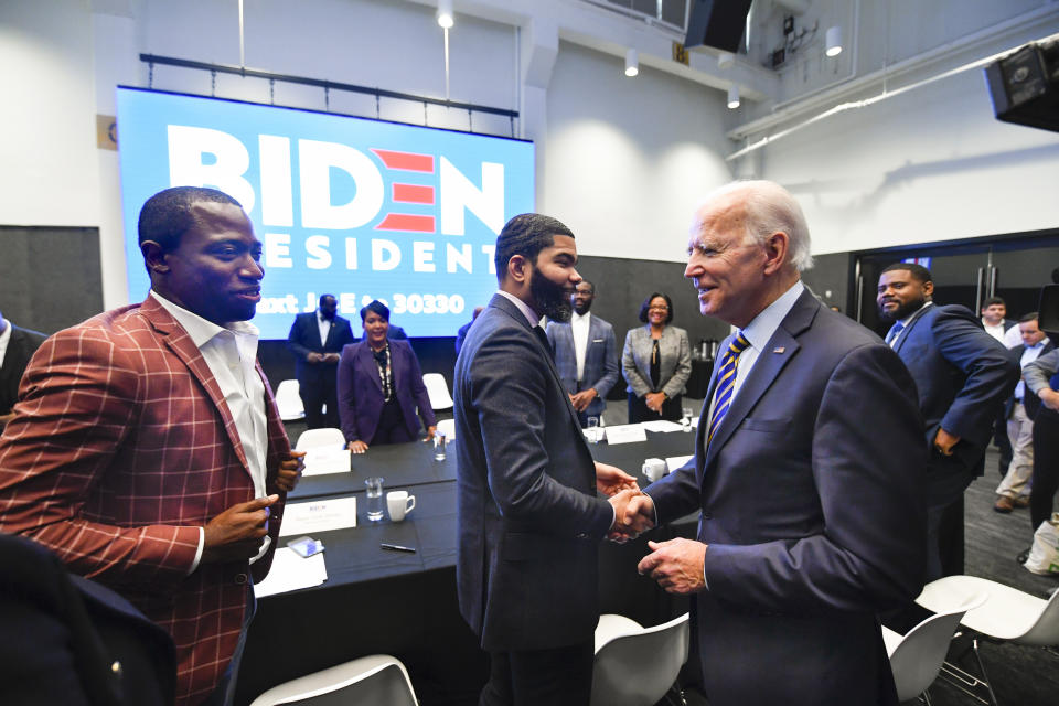 FILE - In this Nov. 21, 2019, file photo, Democratic presidential candidate former Vice President Joe Biden, right, walks around a table meeting with an assembly of Southern black mayors including Mississippi Mayor Chokwe Lumumba and Virginia Mayor Levar Stoney, left, in Atlanta. Biden is leading the most diverse presidential field in history among black voters. (AP Photo/John Amis, File)