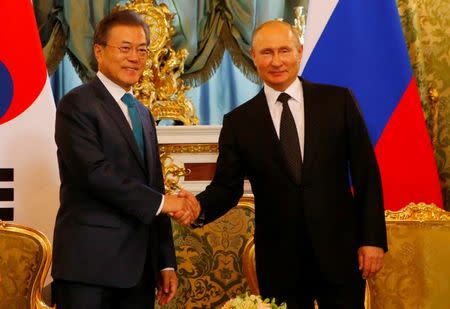 Russian President Vladimir Putin and South Korean President Moon Jae-in shake hands during a meeting at the Kremlin in Moscow, Russia June 22, 2018. REUTERS/Sergei Karpukhin