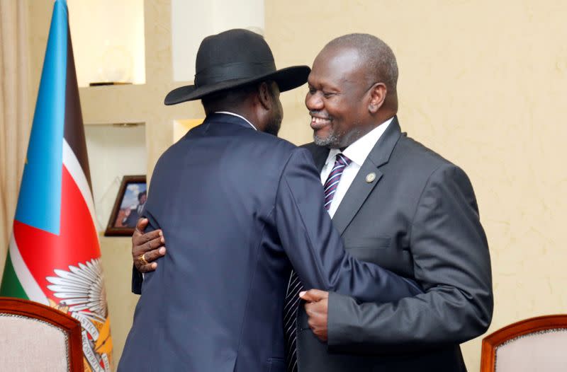 South Sudan's President Salva Kiir Mayardit embraces Riek Machar, ex-vice president and former rebel leader, during their meeting at the State House in Juba