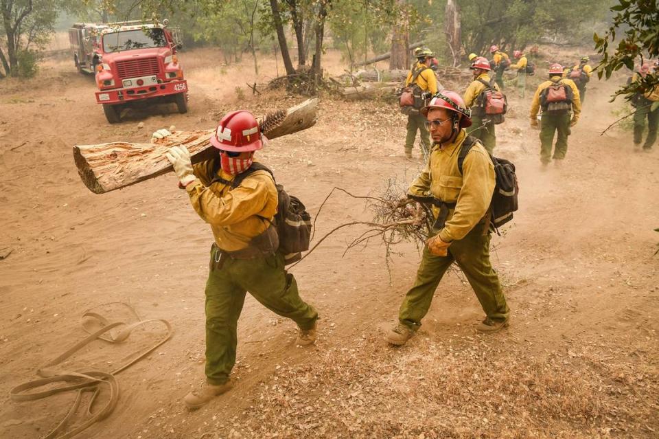 A fire crew clears brush and dried fuels while working to construct a fire break line in the Cascadel Woods area east of North Fork on Thursday, Sept. 10, 2020. The weather has helped with the firefighting efforts on the Creek Fire with far less wind and an inversion layer calming down fire activity.