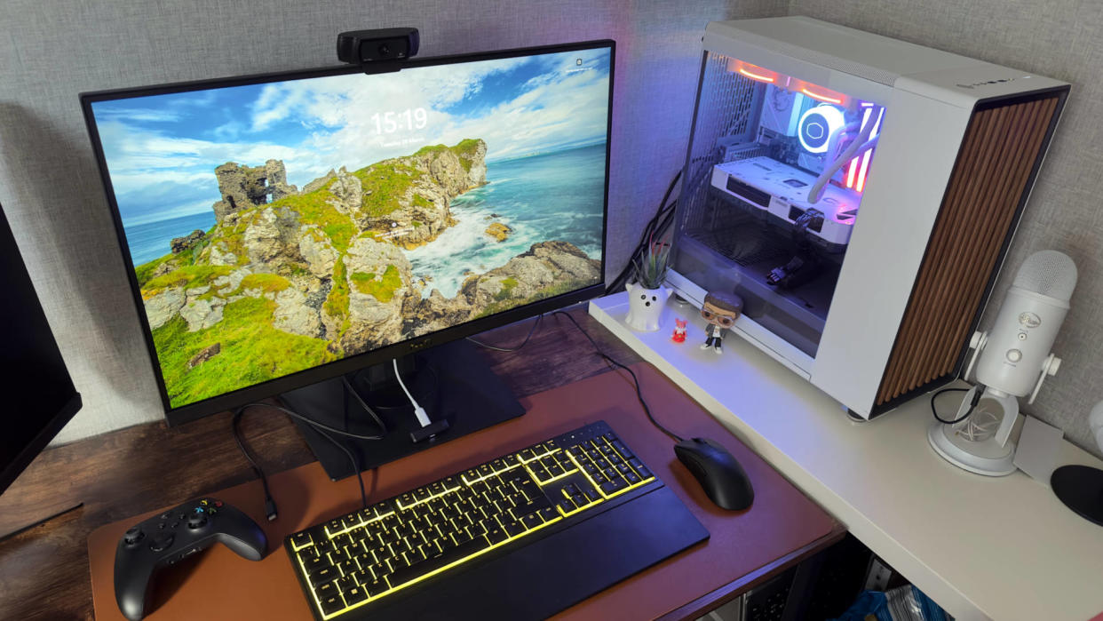  A photograph of a desktop PC next to a large monitor on a desk, with a keyboard and mouse. 