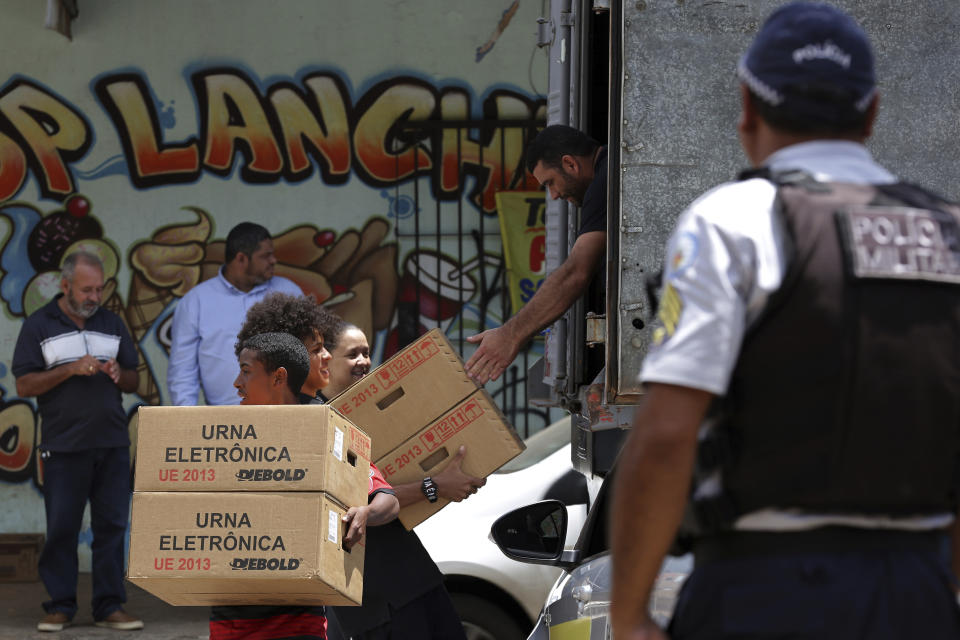 Regional Electoral Court employees deliver voting machines to a polling station at a public school, in Brasilia, Brazil, Friday, Oct. 5, 2018. Brazil's presidential election is set for Oct. 7. (AP Photo/Eraldo Peres)