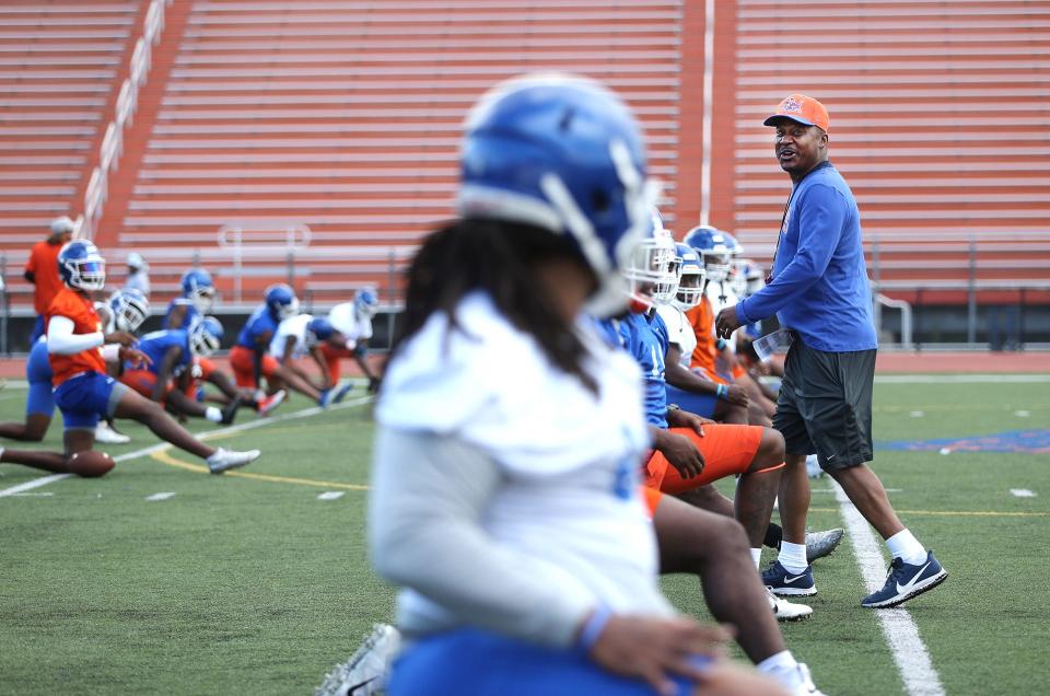 Savannah State University head football coach Aaron Kelton talks to the players as they stretch before practice.