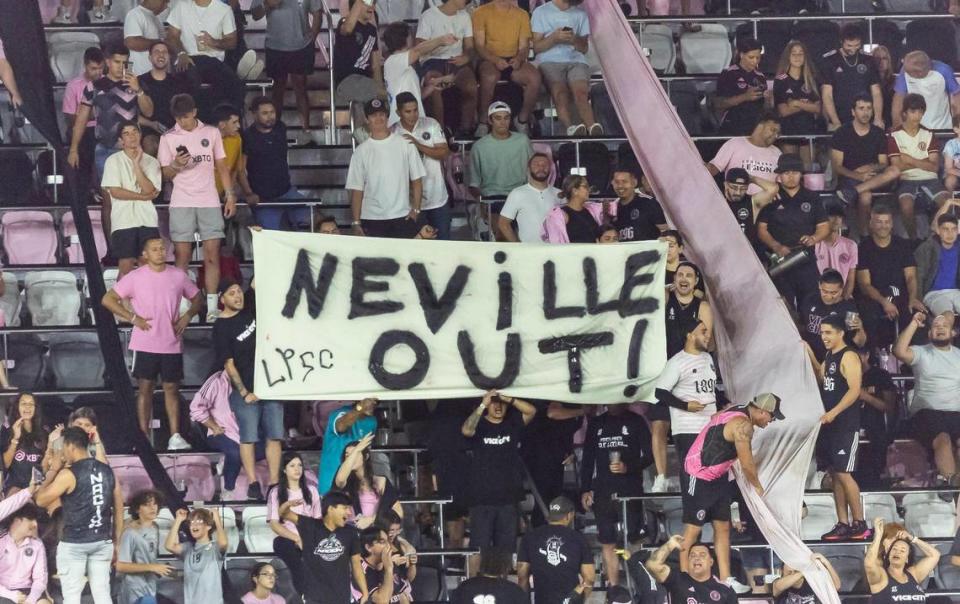 Un grupo de aficionados de la grada de animación del Inter Miami sostiene un cartel que dice “Neville Out”, mientras su equipo jugaba contra los New York Red Bulls, en el partido celebrado el 31 de mayo de 2023 en el DRV PNK Stadium, en Fort Lauderdale, Florida.