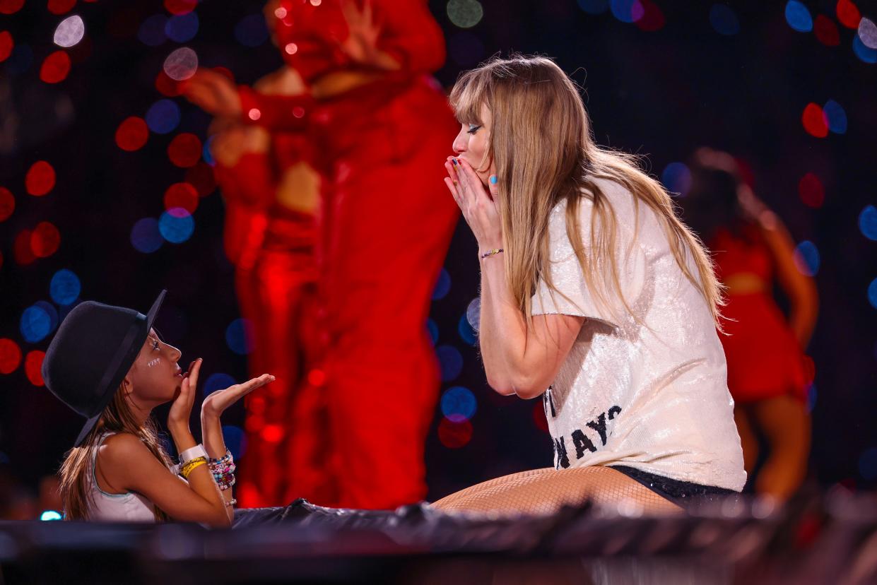A young fan exchanges friendship bracelets with Taylor Swift as she performs onstage during "Taylor Swift | The Eras Tour" at Allianz Parque on November 24, 2023 in Sao Paulo, Brazil.