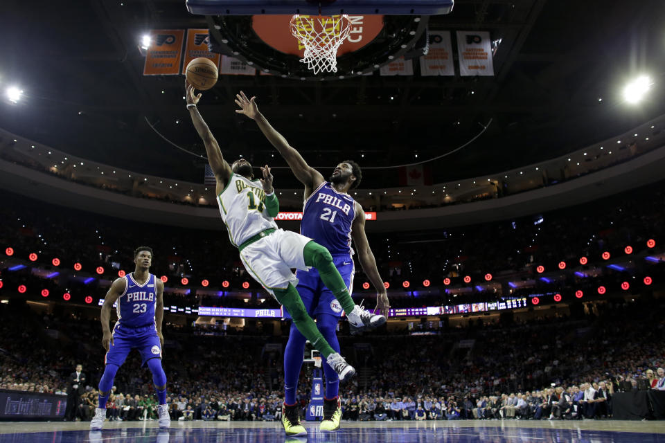 Boston Celtics' Kyrie Irving (11) goes up for a shot past Philadelphia 76ers' Joel Embiid (21) during the first half of an NBA basketball game Wednesday, March 20, 2019, in Philadelphia. (AP Photo/Matt Slocum)