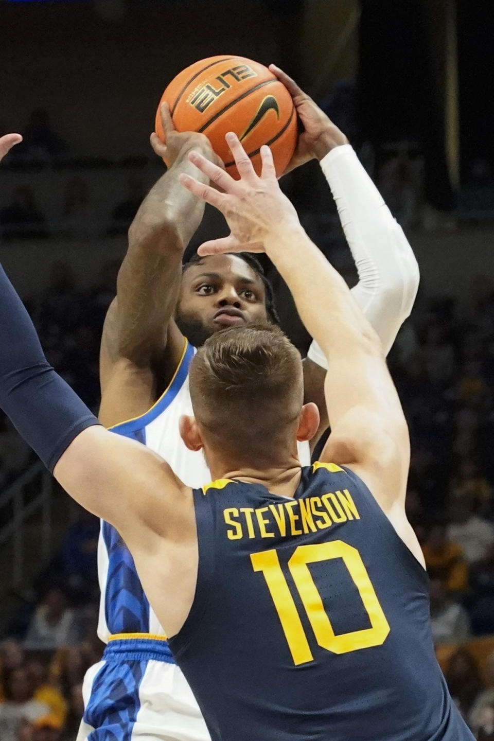 Pittsburgh's Jamarius Burton, top, shoots over West Virginia's Erik Stevenson (10) during the first half of an NCAA college basketball game, Friday, Nov. 11, 2022, in Pittsburgh. (AP Photo/Keith Srakocic)