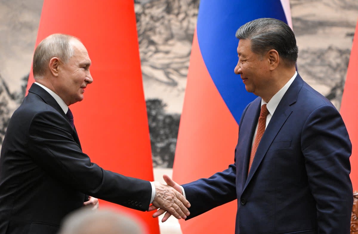 Vladimir Putin and Xi Jinping shake hands for the cameras following their talks in Beijing on Thursday (Pool/AFP via Getty Images)