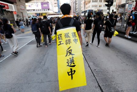 A protester carries a banner during a demonstration to support the city-wide strike and to call for democratic reforms in Mong Kok area in Hong Kong