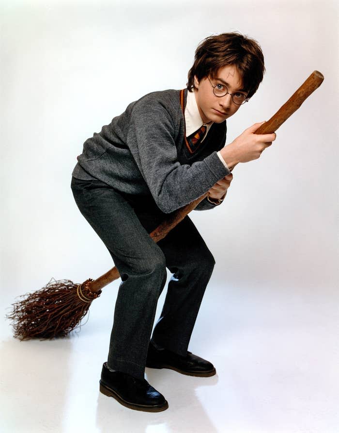 Harry Potter figure poses with wand and broom in Hogwarts uniform