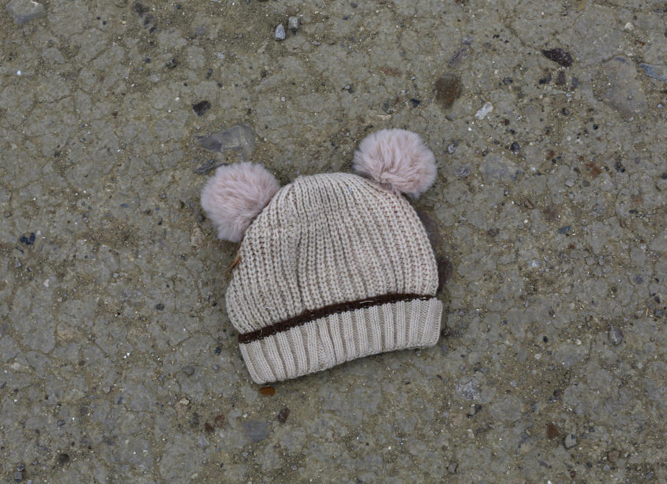 FILE - In this March 28, 2021, file photo, a child's knitted cap lies on the ground near the banks of the Rio Grande river in Roma, Texas. For the third time in seven years, U.S. officials are scrambling to handle a dramatic spike in children crossing the U.S.-Mexico border alone, leading to a massive expansion in emergency facilities to house them as more kids arrive than are being released to close relatives in the United States. (AP Photo/Dario Lopez-Mills, File)