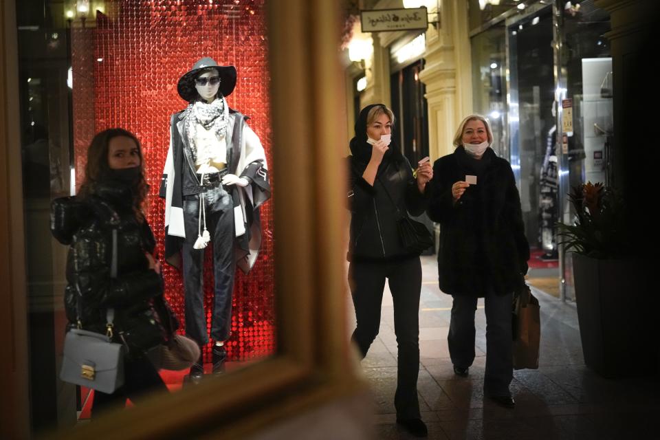 Two women test perfume walking through the GUM department store in Moscow, Russia, Monday, Feb. 14, 2022. While the U.S. warns that Russia could invade Ukraine any day, the drumbeat of war is all but unheard in Moscow, where political experts and ordinary people alike don't expect President Vladimir Putin to launch an attack on the ex-Soviet neighbor. (AP Photo/Alexander Zemlianichenko)