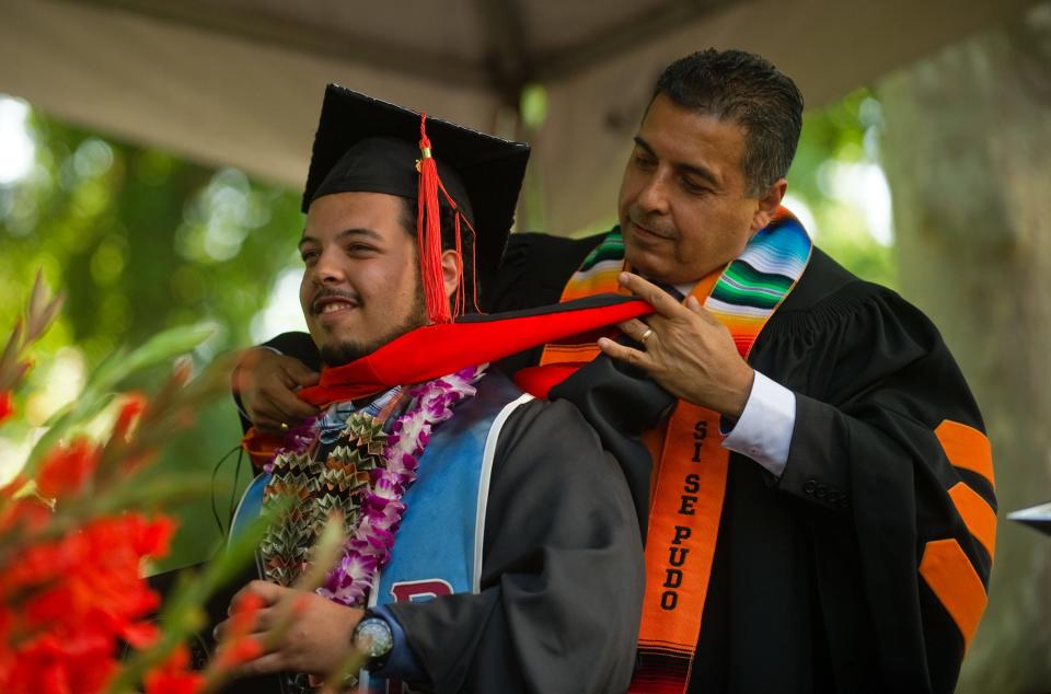 University of the Pacific graduating senior Julio Andres Hernandez, left, is hooded by his father, astronaut and Pacific alum Jose Hernandez, at the Pacific School of Engineering and Computer Science diploma and hooding ceremony May 14, 2016, at Knoles Lawn in Stockton.