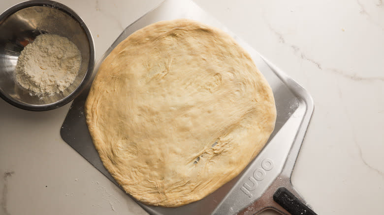 Dough stretched over pizza peel