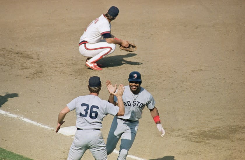 Boston's Dave Henderson slaps high-five with coach Rene Lachemann as Henderson rounds third.