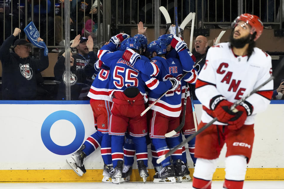 New York Rangers defenseman Ryan Lindgren, left wing Jimmy Vesey and others celebrate following center Mika Zibanejad's goal against the Carolina Hurricanes during the first period in Game 1 of an NHL hockey Stanley Cup second-round playoff series, Sunday, May 5, 2024, in New York. (AP Photo/Julia Nikhinson)