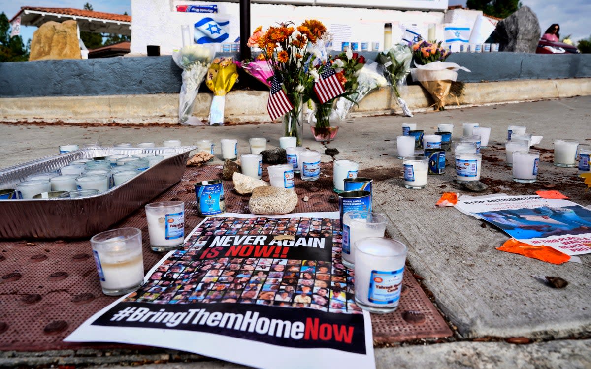 Flowers and candles are left at a makeshift shrine placed at the scene of a Sunday confrontation that lead to death of a demonstrator, Tuesday, Nov. 7, 2023, in Thousand Oaks, Calif. (Copyright 2023 The Associated Press. All rights reserved.)