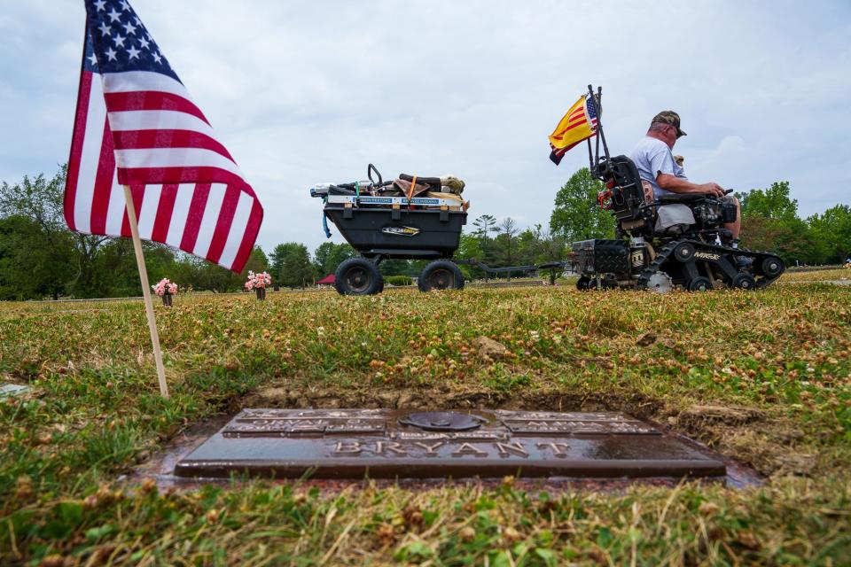 From atop the Garden of Apostles inside Forest Lawn Memory Gardens in Greenwood, Rick Brown makes his way back to his truck Thursday, July 7, 2022, after restoring a bronze grave marker. After each marker is complete, Brown places an American flag.