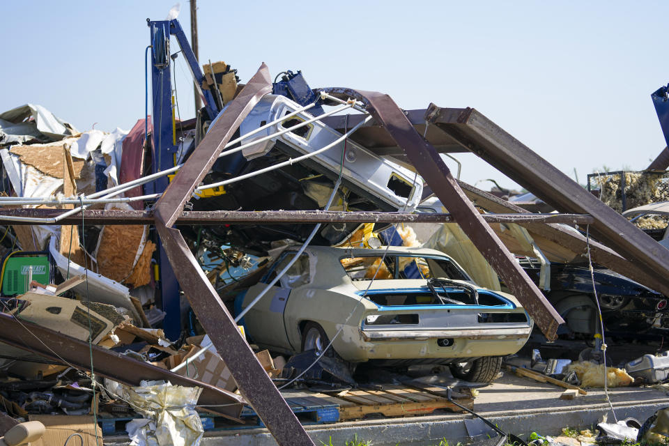 Vehículos en un taller mecánico entre escombros la mañana después de que un tornado atravesar la zona, el domingo 26 de mayo de 2024, en Valle View, Texas. (AP Foto/Julio Cortez)