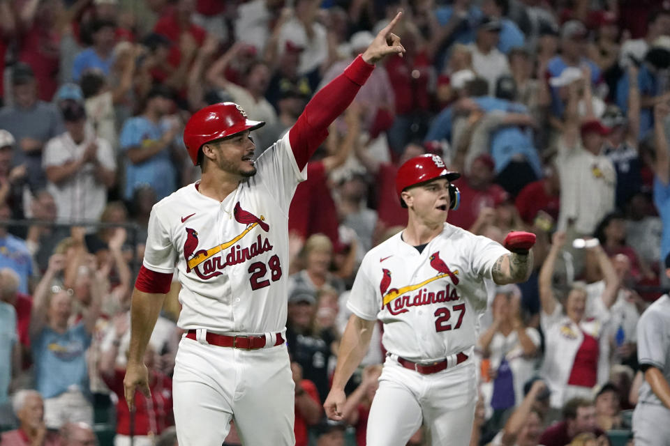 St. Louis Cardinals' Nolan Arenado (28) and Tyler O'Neill (27) celebrate after scoring on a two-run double by St. Louis Cardinals' Paul DeJong during the eighth inning of a baseball game against the New York Yankees Friday, Aug. 5, 2022, in St. Louis. (AP Photo/Jeff Roberson)