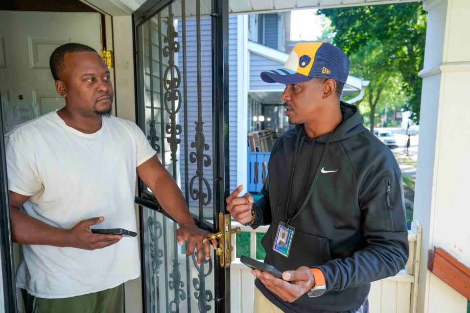 JD Davis listens to  Community Violence Prevention Coordinator Quinn Taylor on Sept. 17 as he tells him about the eight-question survey they want residents to fill out so a new community center can reflect residents' needs.