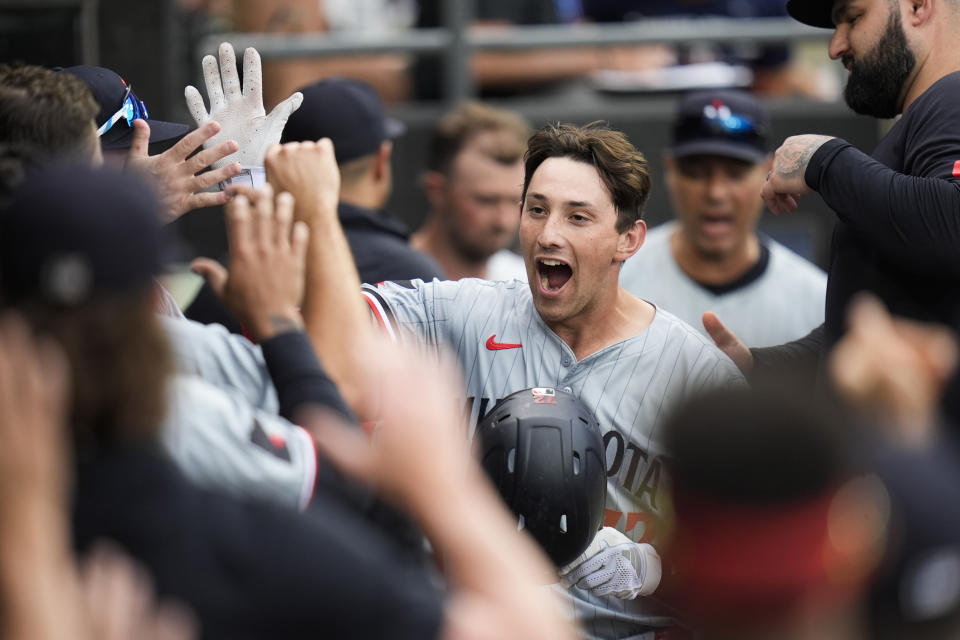 Minnesota Twins' Brooks Lee, center, celebrates with teammates in the dugout after hitting a home run during the sixth inning of the second baseball game of a doubleheader against the Chicago White Sox, Wednesday, July 10, 2024, in Chicago. (AP Photo/Erin Hooley)