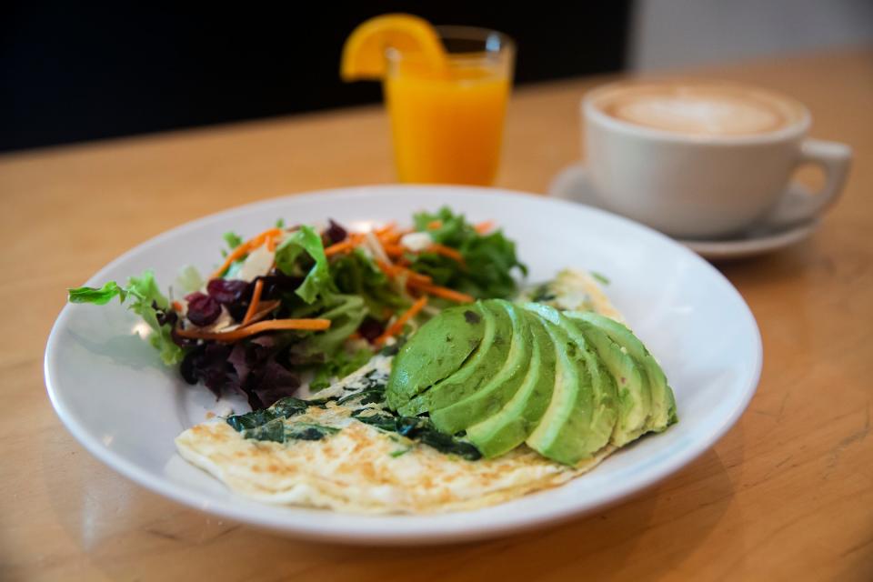 A spinach and avocado omelet, fresh squeezed orange juice and a latte from La Mie Bakery.