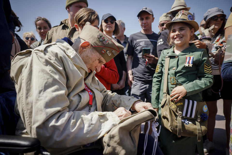 CORRECTS LOCATION A U.S. veteran signs the bag of a World War II enthusiast during a gathering in preparation of the 79th D-Day anniversary in Sainte-Mere-Eglise Normandy, France, Sunday, June 4, 2023. The landings on the coast of Normandy 79 year ago by U.S. and British troops took place on June 6, 1944. (AP Photo/Thomas Padilla)