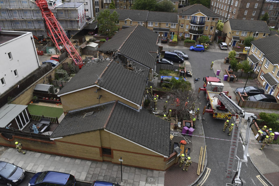 The scene in Bow where a 20-metre crane collapsed on to a property leaving people trapped inside, in east London, Wednesday July 8, 2020. The London Fire Brigade says a 20-meter crane has collapsed onto a block of apartments under development and two houses in east London. The brigade’s Assistant Commissioner Graham Ellis says urban search and rescue crews are undertaking “a complex rescue operation” and using specialized equipment to search the properties on Wednesday. (Dominic Lipinski/PA via AP)