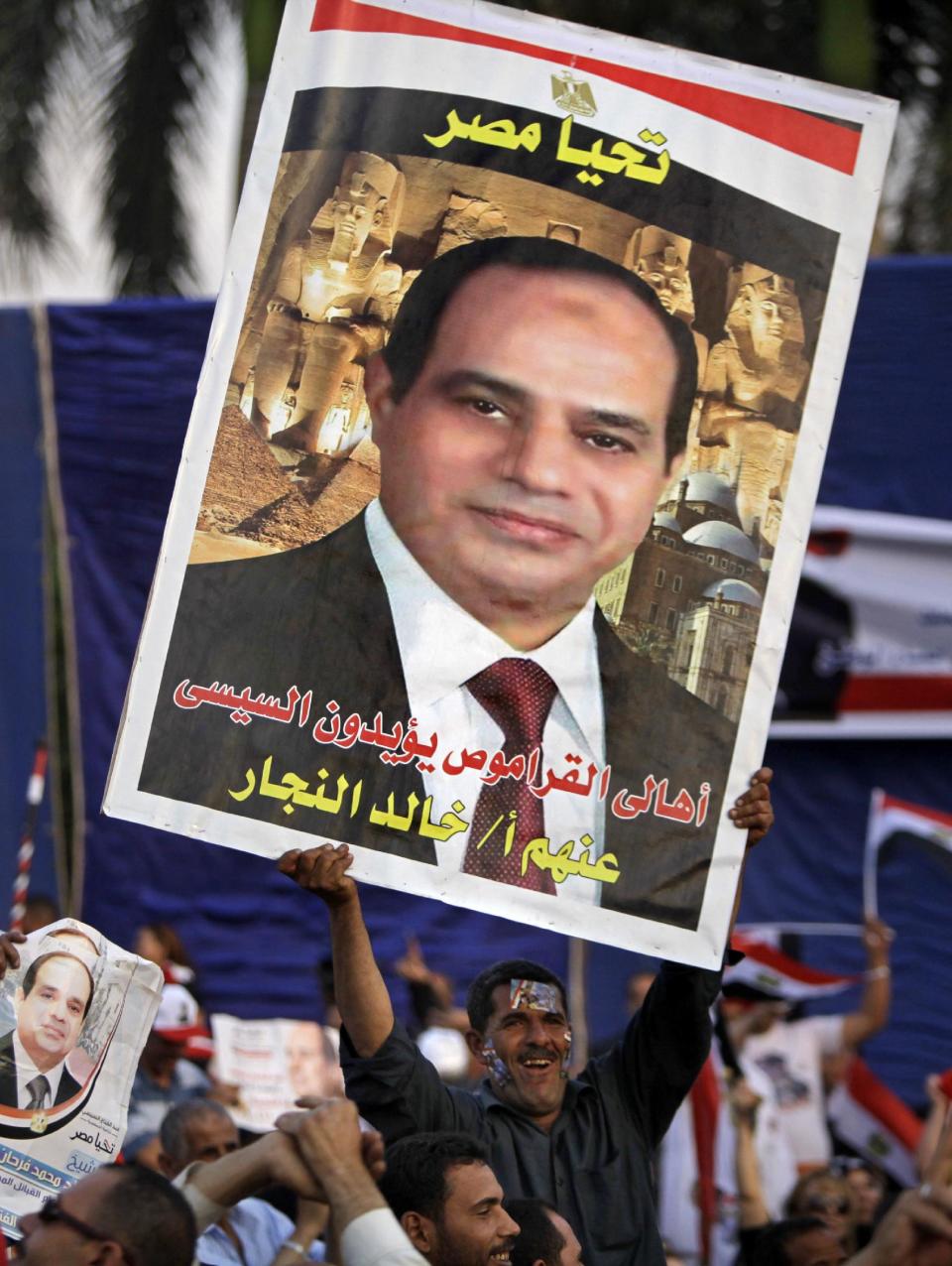 An Egyptian supporter of presidential hopeful Abdel-Fattah el-Sissi, holds a poster with Arabic slogan that reads, "Viva Egypt," during a campaign rally in Cairo, Egypt, Saturday, May 10, 2014. In the first rally to back el-Sissi’s bid for presidency since the campaigning began last week, supporters of the former military chief organized an evening event in the gardens of a Cairo conference center, drawing several thousands -- a much smaller crowd than originally announced. (AP Photo/Amr Nabil)