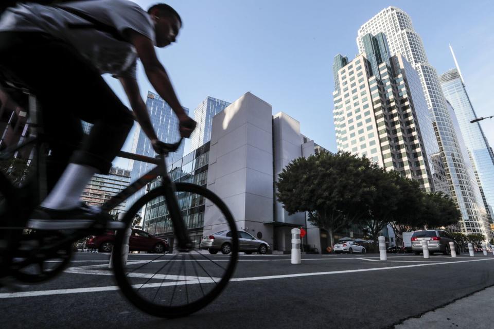 A person rides a bike near the State Bar headquarters.