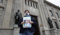 FILE - In this June 10, 2020 file photo, member of Noi Denunceremo (We will denounce) Facebook group, Laura Silvestri holds up a photograph of her father Giuseppe, a COVID-19 victim, in front of Bergamo's court, Italy, Wednesday, June 10, 2020. Noi Denunceremo and affiliated non-profit committee are filing 100 new cases Monday, July 13, 2020, with Bergamo prosecutors, on top of 50 complaints lodged last month. (AP Photo/Antonio Calanni, file)