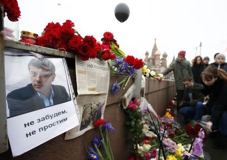 People gather at the site where Boris Nemtsov was recently murdered, with St. Basil's Cathedral seen in the background, in central Moscow, February 28, 2015. The murder of Nemtsov drew condemnation on Saturday from leaders and politicians around the world, who paid tribute to the outspoken critic of President Vladimir Putin and Russia's role in the Ukraine crisis. REUTERS/Sergei Karpukhin