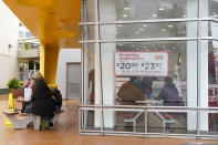 Customers eat at an outdoor bench as others wait for food inside an In-N-Out restaurant in San Francisco's Fisherman's Wharf, Wednesday, Oct. 20, 2021. The In-N-Out hamburger chain is sizzling mad after San Francisco shut down its indoor dining for refusing to check customers' vaccination status. The company's Fisherman's Wharf location, its only one in San Francisco, was temporarily shut by the Department of Public Health on Oct. 14. (AP Photo/Jeff Chiu)