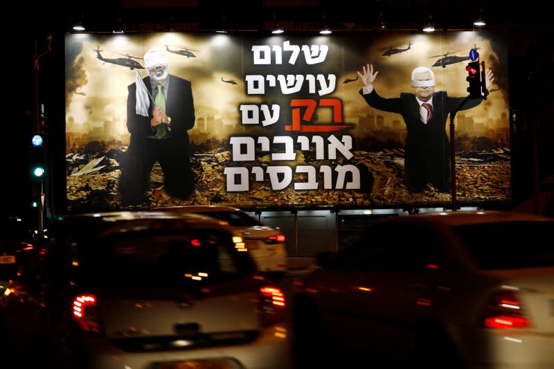 A billboard over a Tel Aviv highway shows photo-shopped warzone images of Palestinian President Mahmoud Abbas and Hamas leader Ismail Haniyeh, both blindfolded, with the slogan read in Hebrew "Peace is Made ONLY with Defeated Enemies\