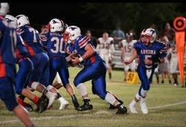 Easton Smith (pictured right) shown after a handoff during his days as a quarterback for Arkoma.