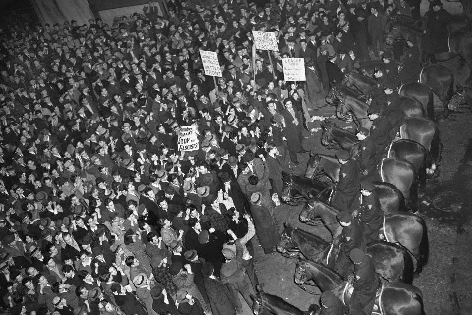 FILE -- This Feb. 20, 1939 file photo shows New York City's mounted police forming a line outside Madison Square Garden to hold in check a crowd that packed the streets where the German American Bund was holding a rally. The pro-Hitler rally that took place 80 years ago this week at New York’s Madison Square Garden is the subject of a short documentary that’s up for an Oscar this Sunday, Feb. 24, 2019. The film directed by Marshall Curry is called a “A Night at the Garden.” (AP Photo/Murray Becker, File)