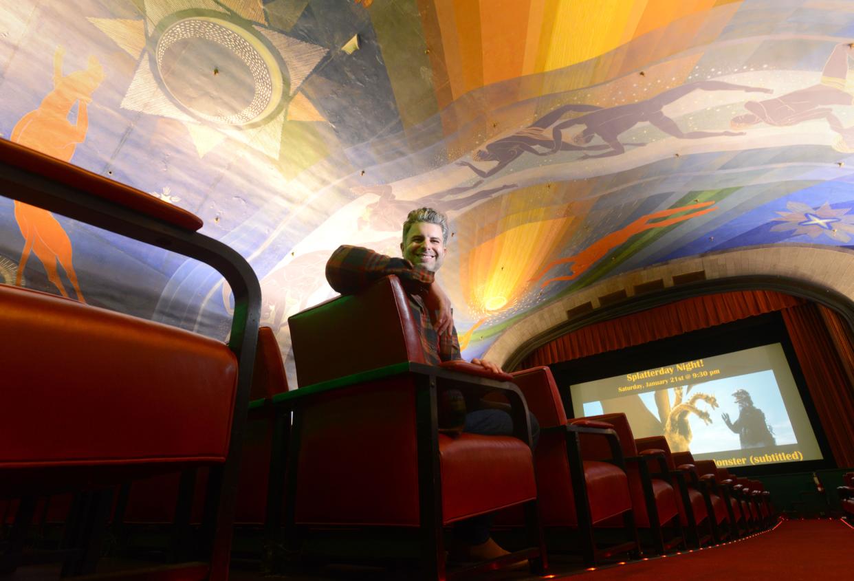 In 2023, the executive director of the Cape Cinema, Josh Mason, sits underneath the theater's Rockwell Kent mural.