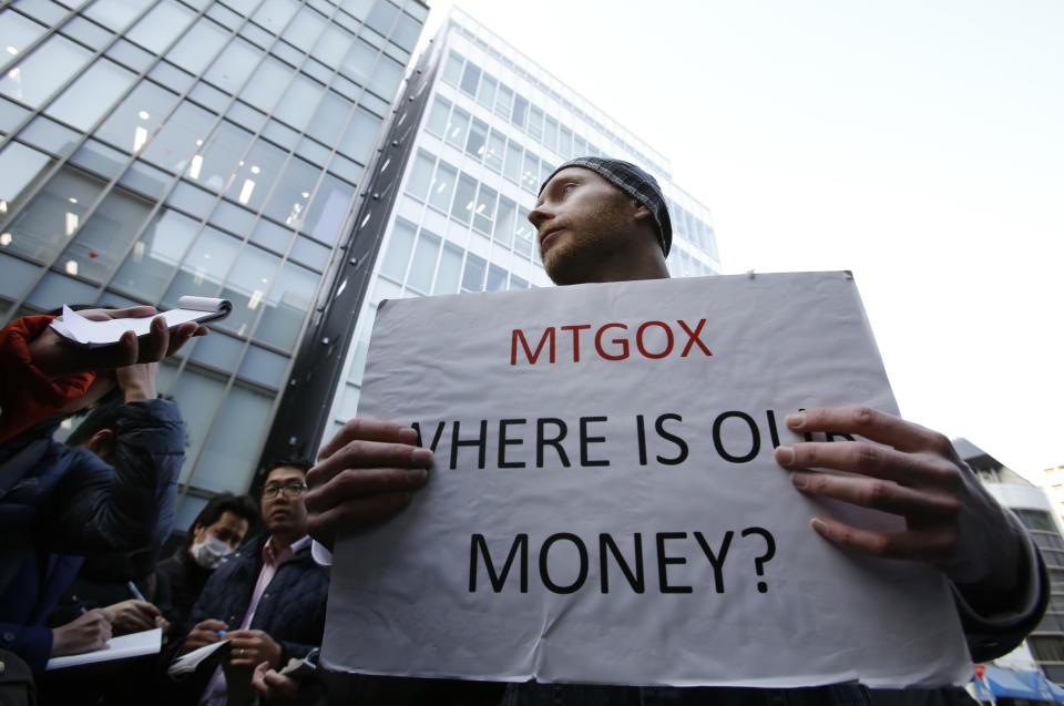 Kolin Burges, a self-styled cryptocurrency trader and former software engineer from London, holds a placard to protest against Mt. Gox, in front of the building where the digital marketplace operator was formerly housed in Tokyo February 26, 2014. Japanese authorities are looking into the abrupt closure of Mt. Gox, the top government spokesman said on Wednesday in Tokyo's first official reaction to the turmoil at what was the world's biggest exchange for bitcoin virtual currency. REUTERS/Toru Hanai (JAPAN - Tags: BUSINESS SCIENCE TECHNOLOGY CIVIL UNREST)