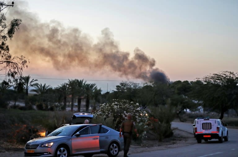 Israeli security forces gather at Israel-Gaza border near the kibbutz of Kfar Aza, as smoke rises from a bus that was reportedly hit by a rocket fired from the Palestinian enclave on November 12, 2018