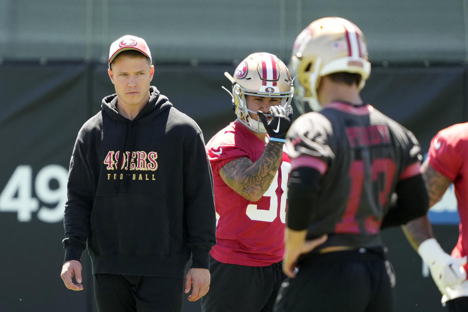 San Francisco 49ers running back Christian McCaffrey, left, watches quarterback Brock Purdy (13) take part in drills during NFL football practice in Santa Clara, Calif., Tuesday, June 4, 2024. (AP Photo/Tony Avelar)