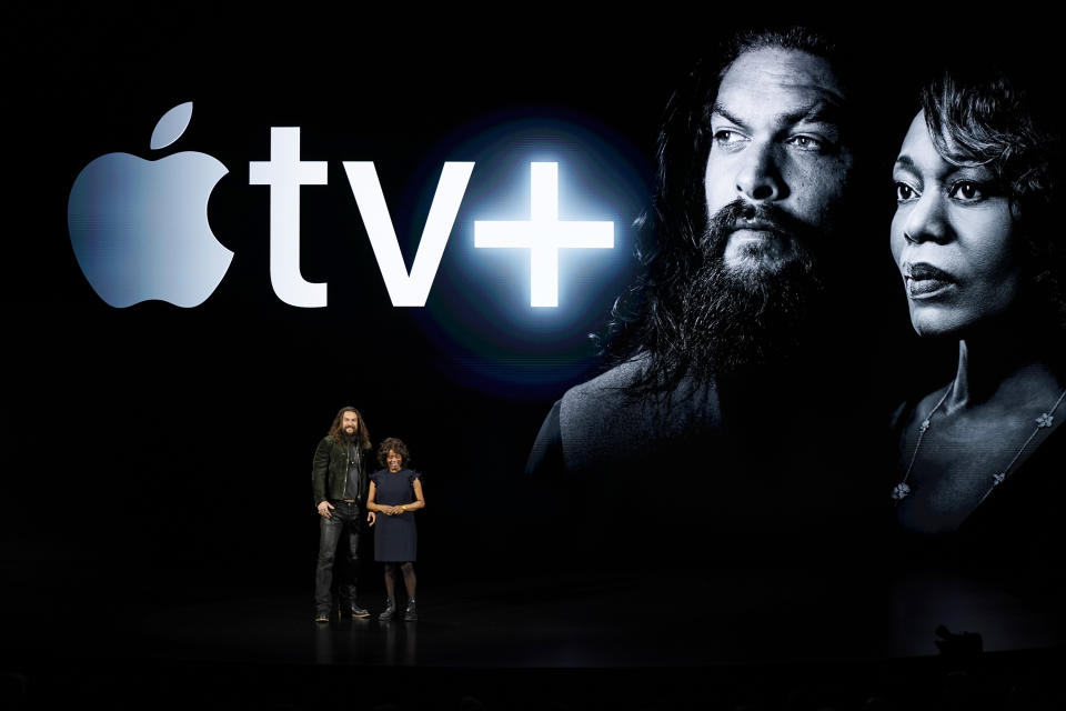 Actors Jason Momoa, left, and Alfre Woodard speak at the Steve Jobs Theater during an event to announce new Apple products Monday, March 25, 2019, in Cupertino, Calif. (AP Photo/Tony Avelar)