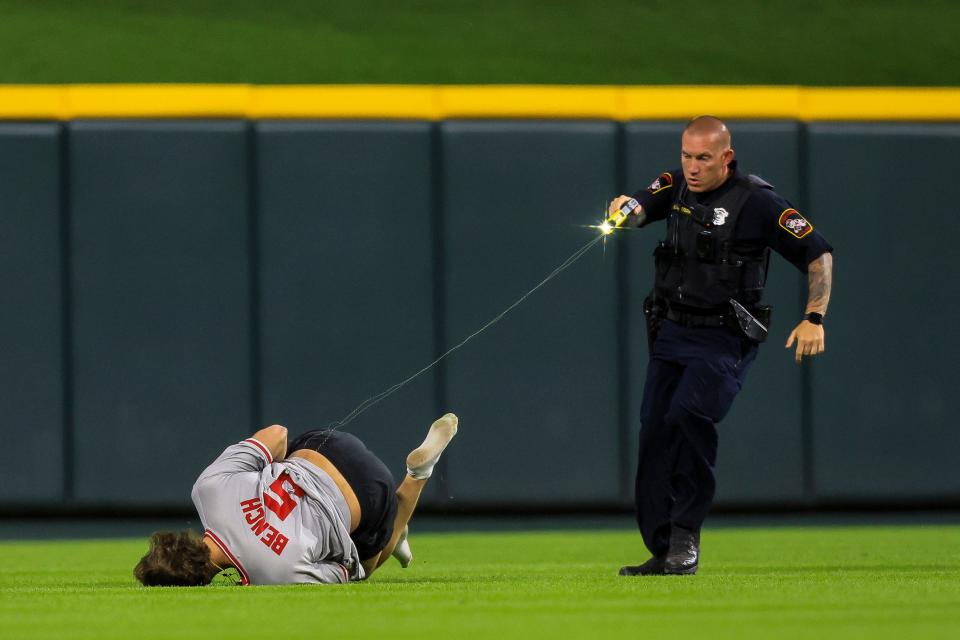 A police officer tases a Cincinnati Reds fan after the fan ran onto the field at Great American Ball Park