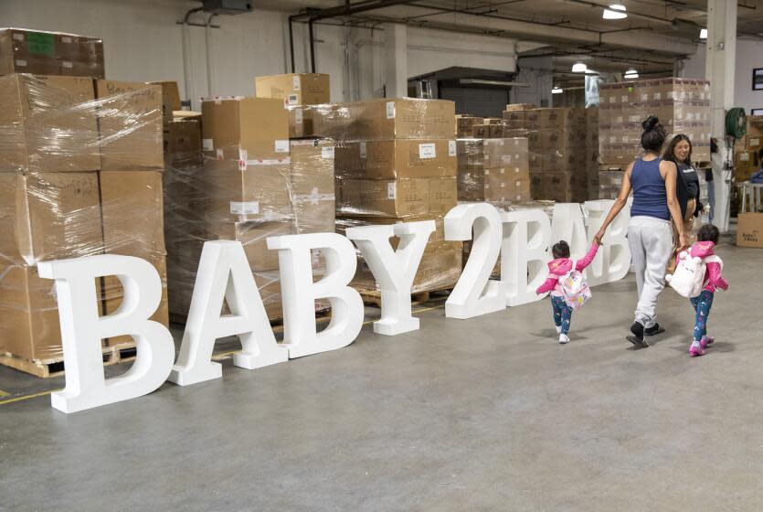 LOS ANGELES, CA-MAY 19, 2023: A mother and her children visit Baby2Baby, a non-profit organization in Los Angeles that provides children and mothers living in poverty with diapers, formula, clothing, and the basic necessities, serving more than one million children across all 50 states. Vice President Kamala Harris received a tour of their headquarters and met with a number of mothers and their children. (Mel Melcon / Los Angeles Times)