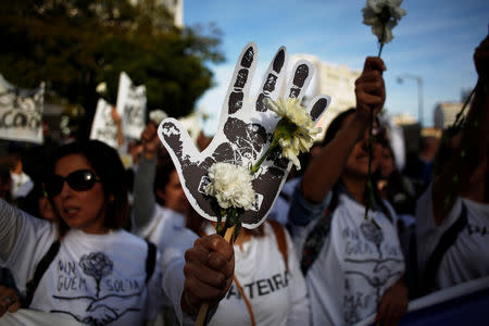 Nurses hold white carnations during a protest march in Lisbon, Portugal, March 8, 2019. REUTERS/Pedro Nunes